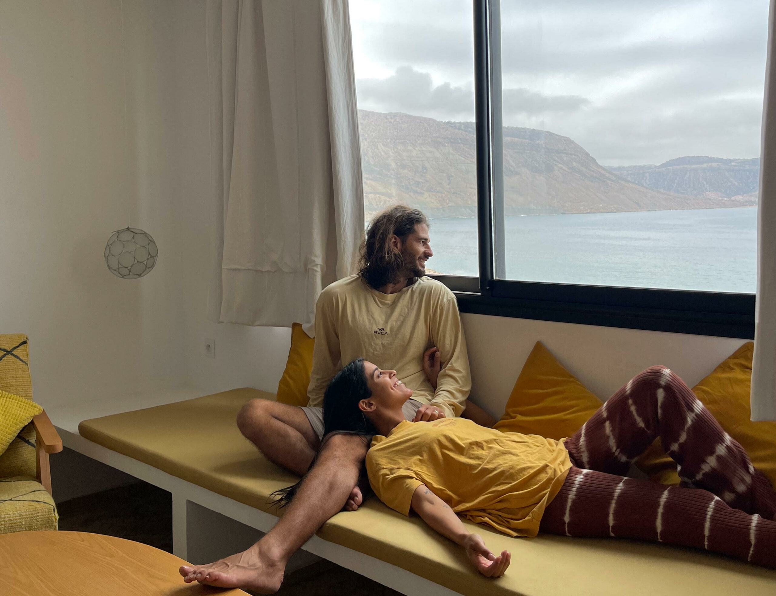 דור ועמית בחדר מלון משקיפים על הים