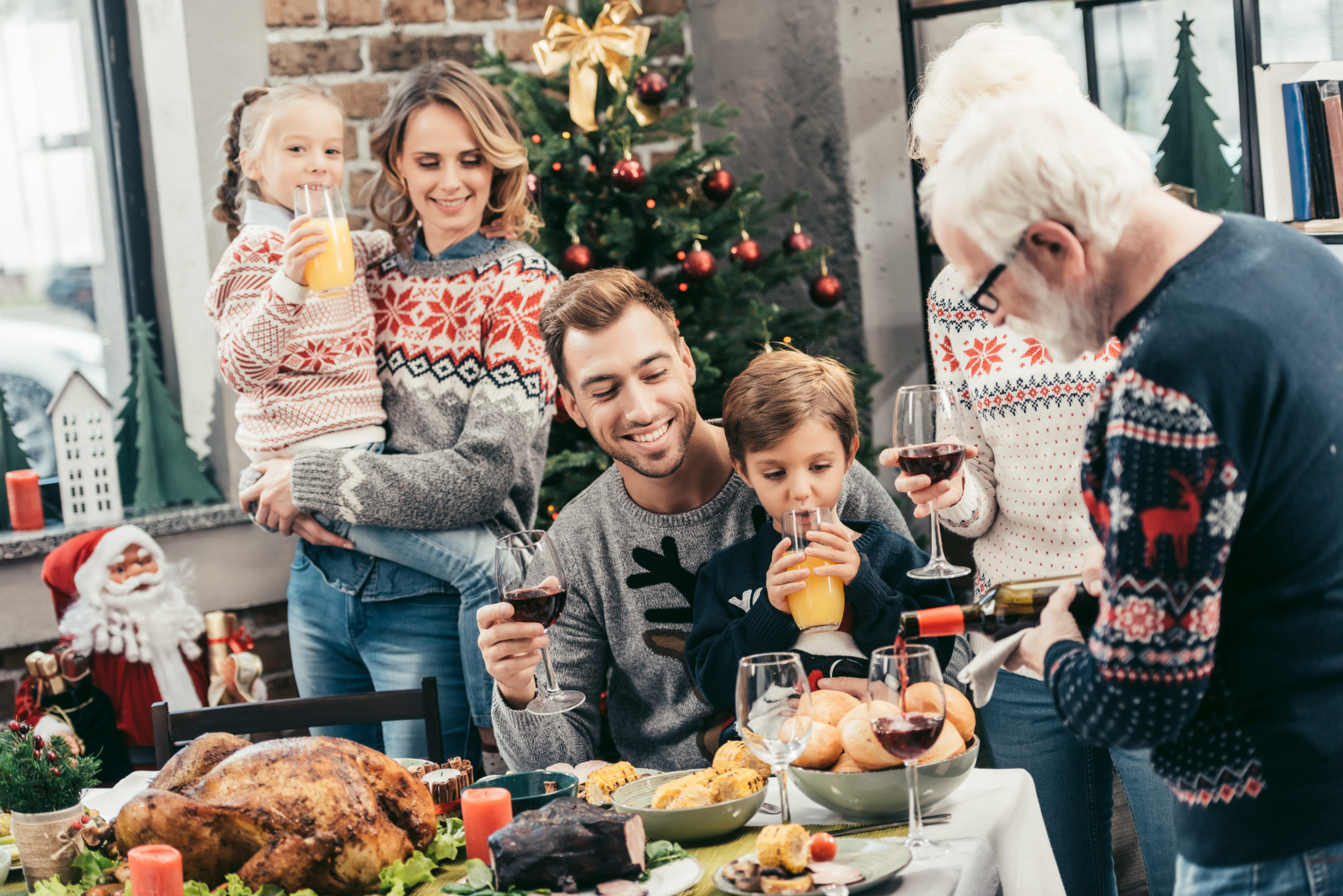 משפחה חוגגת כריסמס ליד העץ