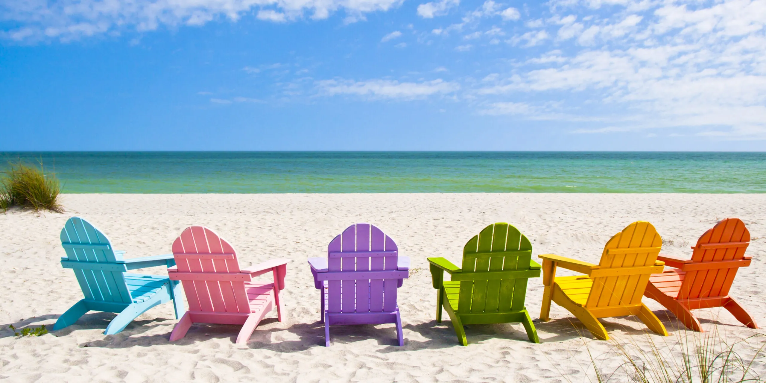כסאות על חוף ים בצבעי גאווה 